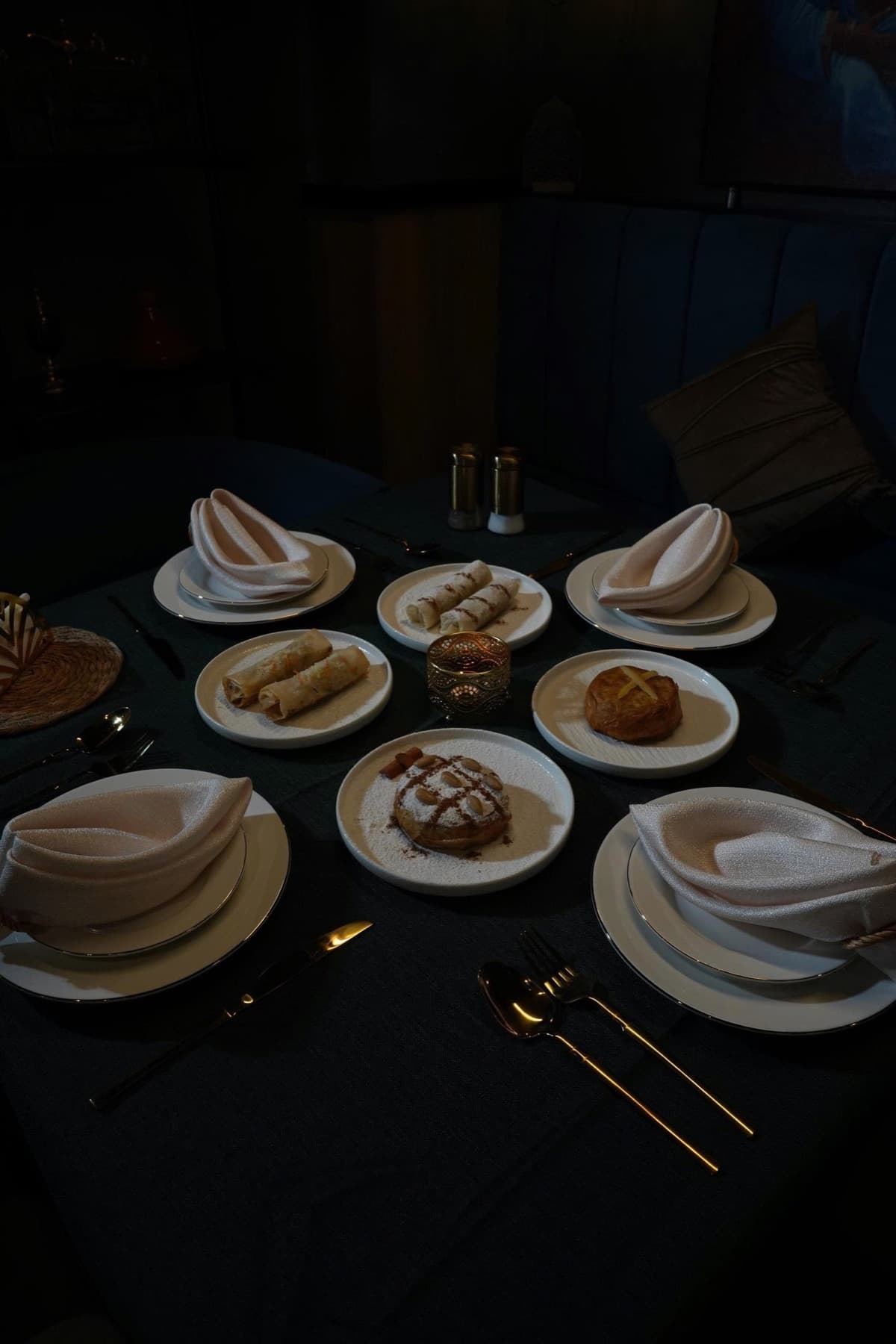 A Moroccan table set at Naadi: pastries, white napkins, gold cutlery